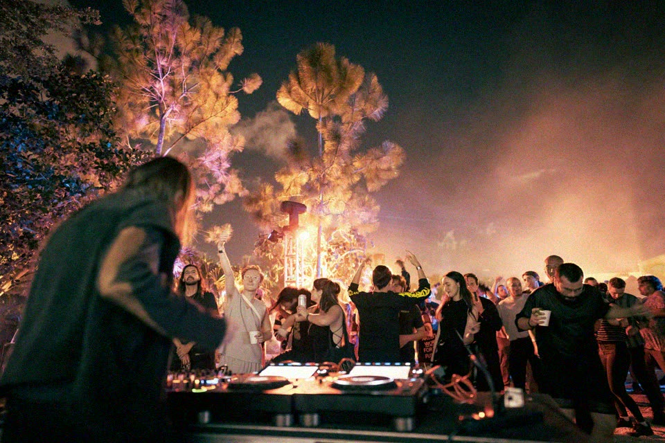 A DJ playing to a crowd in the Yard at night