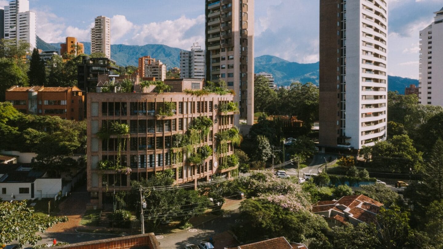 Mixed-use building in Medellín, Colombia, featuring apartments, offices and restaurants. Its unique volumetry is determined by the corner curves of the lot where it is located. 2019 by ALH Architecture This project achieves an urban response to its immediate surroundings with a commercial plinth and living space. It has thick gardens at height with a great variety of species generating dynamism on the facades. The materials used are brick, steel and glass, which last over time and, due to their texture and colour, allow the building to blend into its surroundings