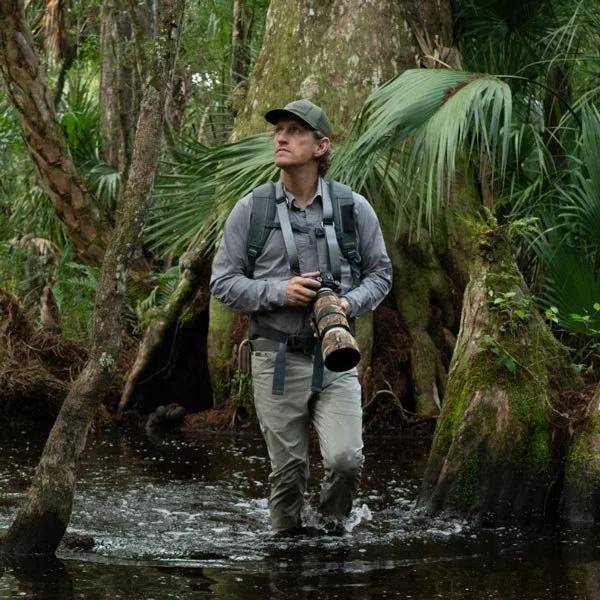 Nature photographer wading through a cypress swamp on a ChoZen eco tour