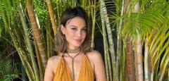 Nathalie Kelley, actor and environmental activist, smiling in front of bamboo palms