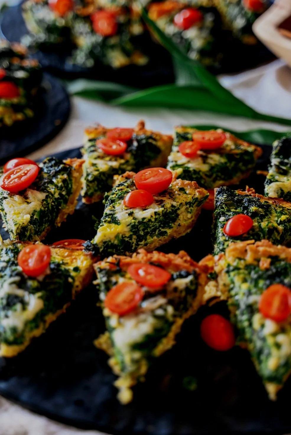 Spinach and tomato frittata slices served during a ChoZen culinary exploration on the land